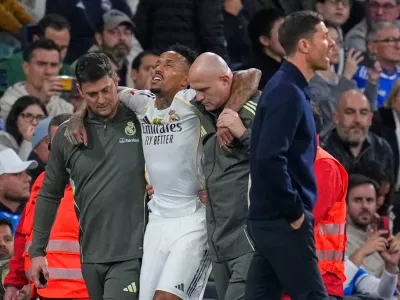Real Madrid's Eder Militao is assisted from the pitch after getting an injury during the Spanish La Liga soccer match between Real Madrid and Celta Vigo in Madrid, Spain, Sunday, Dec. 7, 2025. (AP Photo/Manu Fernandez)