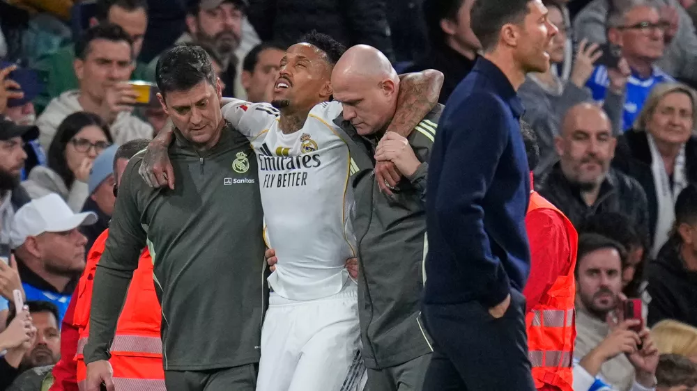 Real Madrid's Eder Militao is assisted from the pitch after getting an injury during the Spanish La Liga soccer match between Real Madrid and Celta Vigo in Madrid, Spain, Sunday, Dec. 7, 2025. (AP Photo/Manu Fernandez)