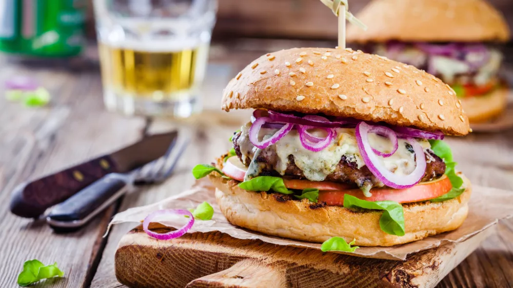homemade burger with beef cutlet, apple, lettuce, onion and blue cheese on wooden table