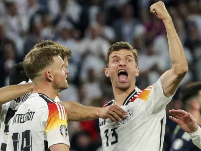 FILE - Germany's Thomas Mueller, right, celebrates during the Group A match between Germany and Scotland at the Euro 2024 soccer tournament in Munich, Germany, Friday, June 14, 2024. Germany forward Thomas M&uuml;ller has announced his retirement from international soccer after a 14-year career that included the 2014 World Cup title. (Christian Charisius/dpa via AP, File)