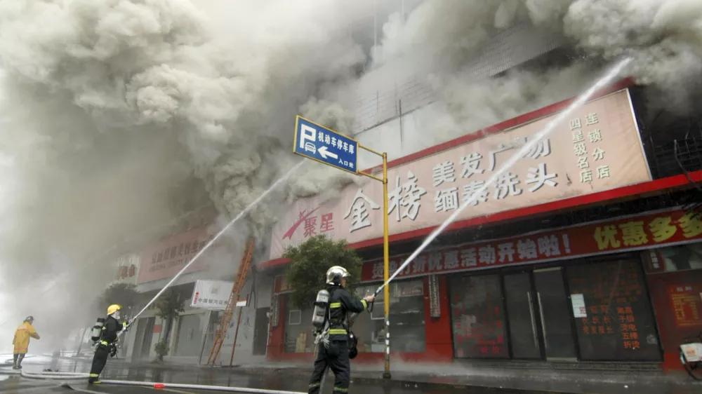 Firemen put out a fire at a building in Wenzhou, Zhejiang province, December 12, 2007. The fire in a ground-floor flower shop in east China spread into a block of apartments above on Wednesday, killing at least 19 people, media said. REUTERS/China Daily (CHINA) CHINA OUT