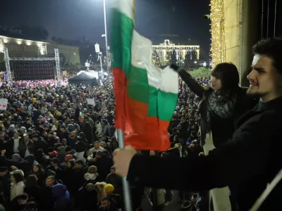 Students wave Bulgarian flag as as a swelling crowd of tens of thousands of Bulgarians filled Sofia's central square, demanding the government's resignation amid rising anger over corruption and contested economic policies, Sofia, Bulgaria, Wednesday, Dec. 10, 2025. (AP Photo/Valentina Petrova)