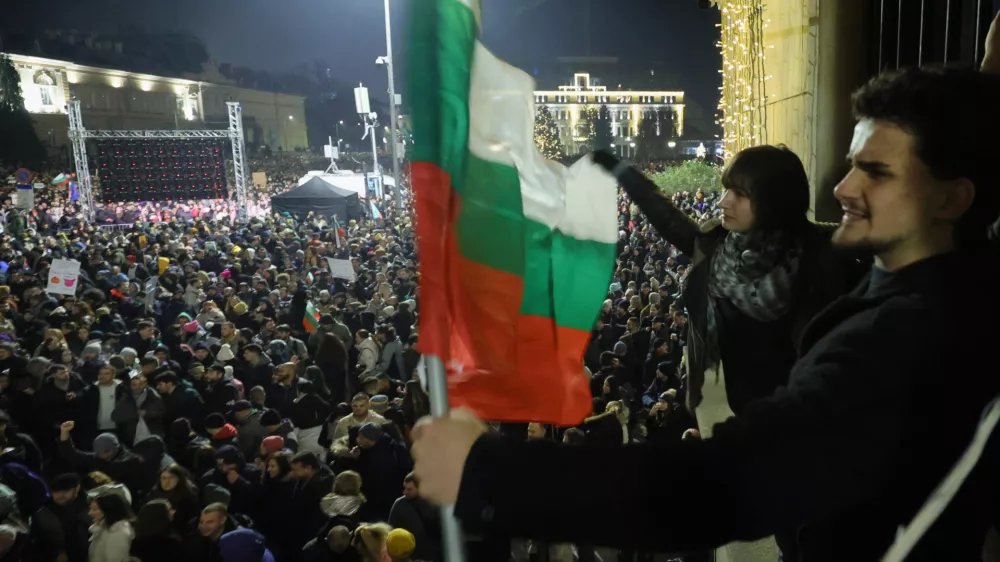 Students wave Bulgarian flag as as a swelling crowd of tens of thousands of Bulgarians filled Sofia's central square, demanding the government's resignation amid rising anger over corruption and contested economic policies, Sofia, Bulgaria, Wednesday, Dec. 10, 2025. (AP Photo/Valentina Petrova)
