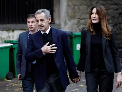 Former French President Nicolas Sarkozy leaves his house with his wife Carla Bruni-Sarkozy on the day of his incarceration at the Sante prison to begin his five-year prison sentence for criminal conspiracy over attempts to raise campaign funds from Libya, in Paris, France, October 21, 2025. REUTERS/Benoit Tessier