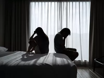 Depressed couple having a problem sitting head in hands in the dark bedroom, Negative emotion and mental health concept / Foto: Kitzcorner