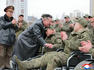 North Korean leader Kim Jong Un embraces a soldier during a welcoming ceremony for members of the 528th Engineer Regiment after they returned from an overseas mission, at the April 25 Cultural and Tourism Center in Pyongyang, North Korea, December 12, 2025, in this picture released by North Korea's official Korean Central News Agency on December 13, 2025. REUTERS/KCNA  KCNA via REUTERS  ATTENTION EDITORS - THIS IMAGE WAS PROVIDED BY A THIRD PARTY. REUTERS IS UNABLE TO INDEPENDENTLY VERIFY THIS IMAGE. NO THIRD PARTY SALES. SOUTH KOREA OUT. NO COMMERCIAL OR EDITORIAL SALES IN SOUTH KOREA.