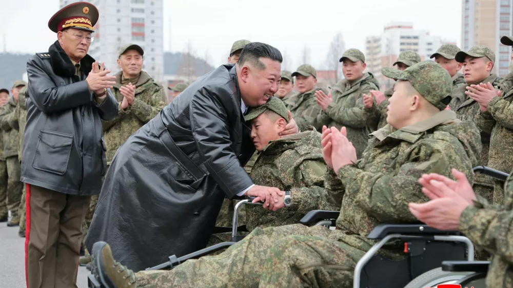 North Korean leader Kim Jong Un embraces a soldier during a welcoming ceremony for members of the 528th Engineer Regiment after they returned from an overseas mission, at the April 25 Cultural and Tourism Center in Pyongyang, North Korea, December 12, 2025, in this picture released by North Korea's official Korean Central News Agency on December 13, 2025. REUTERS/KCNA  KCNA via REUTERS  ATTENTION EDITORS - THIS IMAGE WAS PROVIDED BY A THIRD PARTY. REUTERS IS UNABLE TO INDEPENDENTLY VERIFY THIS IMAGE. NO THIRD PARTY SALES. SOUTH KOREA OUT. NO COMMERCIAL OR EDITORIAL SALES IN SOUTH KOREA.