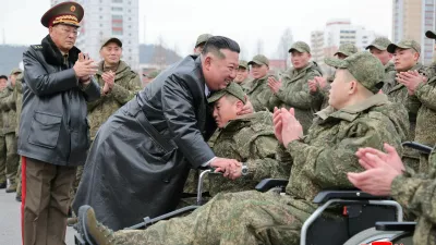 North Korean leader Kim Jong Un embraces a soldier during a welcoming ceremony for members of the 528th Engineer Regiment after they returned from an overseas mission, at the April 25 Cultural and Tourism Center in Pyongyang, North Korea, December 12, 2025, in this picture released by North Korea's official Korean Central News Agency on December 13, 2025. REUTERS/KCNA  KCNA via REUTERS  ATTENTION EDITORS - THIS IMAGE WAS PROVIDED BY A THIRD PARTY. REUTERS IS UNABLE TO INDEPENDENTLY VERIFY THIS IMAGE. NO THIRD PARTY SALES. SOUTH KOREA OUT. NO COMMERCIAL OR EDITORIAL SALES IN SOUTH KOREA.
