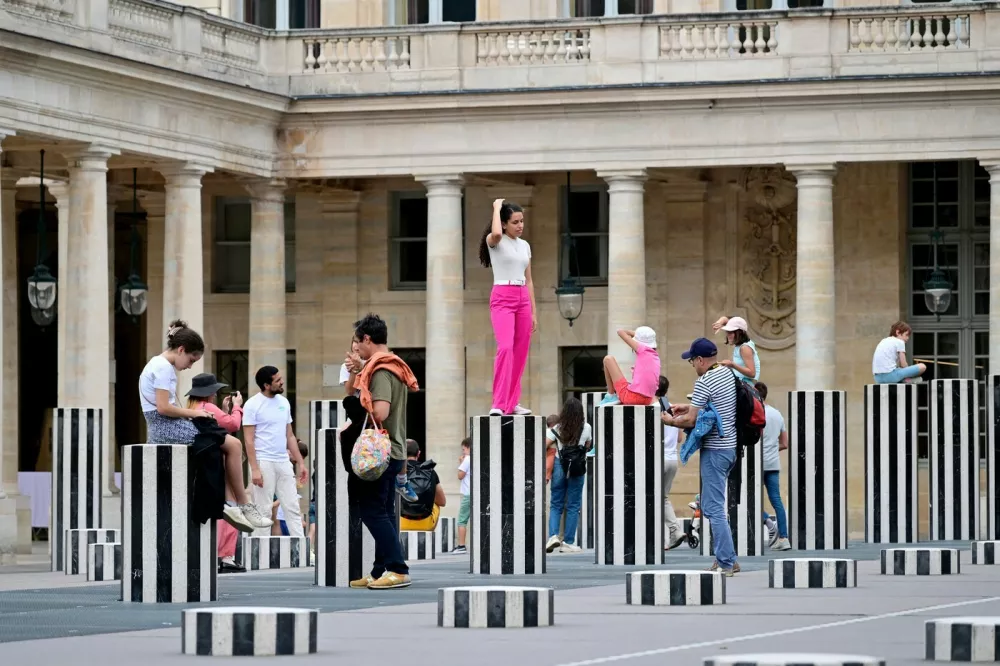 People visit "Les Deux Plateaux", commonly known as "Columns of Buren", by French artist Daniel Buren and architect Patrick Bouchain, on August 8, 2023 in the main courtyard of the Palais-Royal in Paris.,Image: 795490928, License: Rights-managed, Restrictions: RESTRICTED TO EDITORIAL USE - MANDATORY MENTION OF THE ARTIST UPON PUBLICATION - TO ILLUSTRATE THE EVENT AS SPECIFIED IN THE CAPTION, Model Release: no