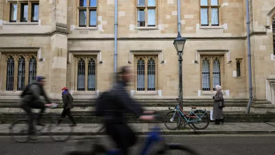 FILE PHOTO: People walk and cycle past a building at Oxford University in Oxford, Britain, December 5, 2025. REUTERS/Jaimi Joy/File Photo