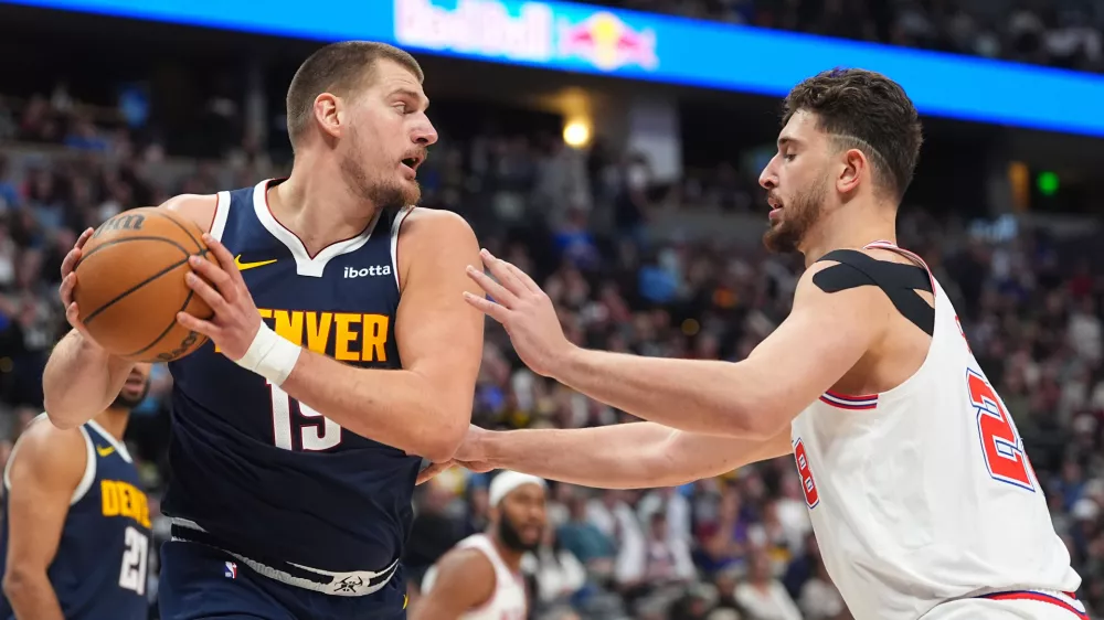 Denver Nuggets center Nikola Jokic pulls in a rebound as Houston Rockets center Alperen Sengun defends in the second half of an NBA basketball game Monday, Dec. 15, 2025, in Denver. (AP Photo/David Zalubowski)