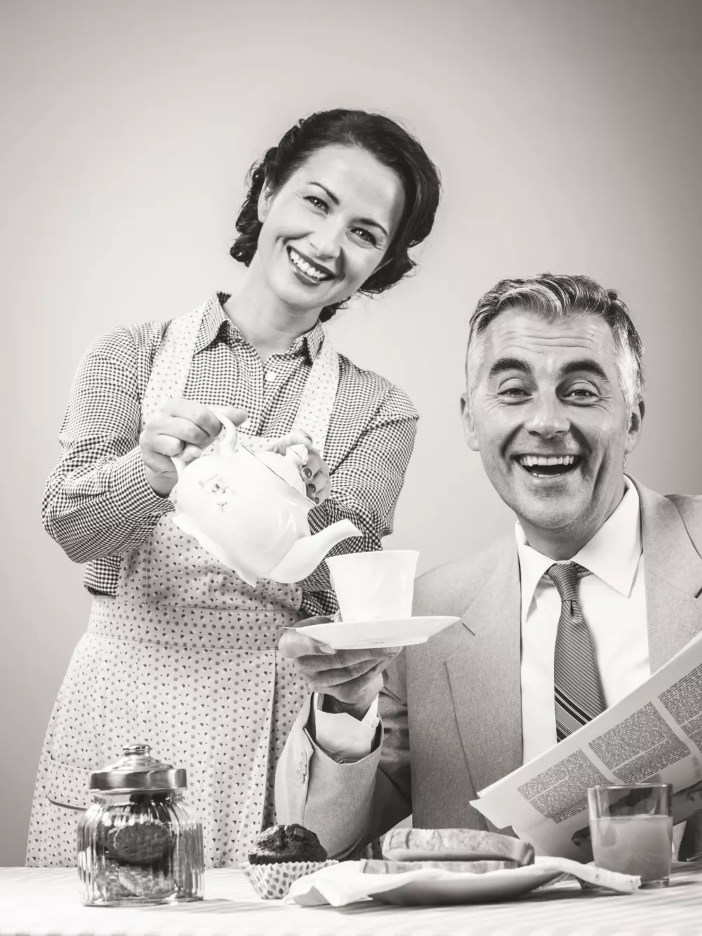 1950s beautiful woman serving tea for breakfast to her smiling husband / Foto: Cyano66
