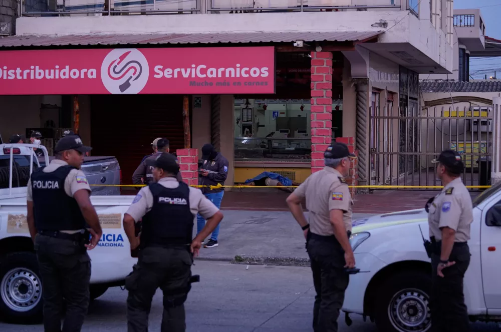 Police work the scene as the body of slain soccer player Mario Pineida lies on the floor at a butcher shop in Guayaquil, Ecuador, Wednesday, Dec. 17, 2025. (AP Photo/Cesar Munoz)