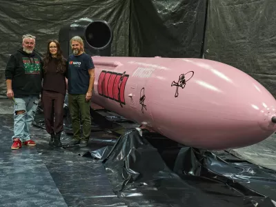 Jan Polak, right, and Martin Ondracek, left, from the Czech organization, Weapons to Ukraine, together with Iryna Terekh, Chief Technology Officer of the Fire Point factory, center, pose for photo by a Flamingo cruise missile, which was paid for by Czech crowdfunding campaign, at the Fire Point factory at an undisclosed location in Ukraine, Sunday, Nov. 16, 2025. (AP Photo/Efrem Lukatsky)