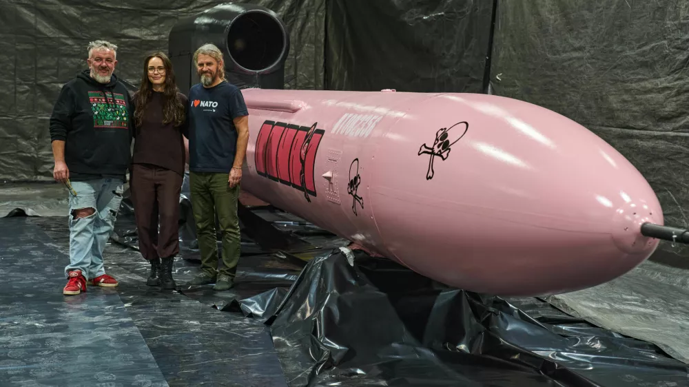 Jan Polak, right, and Martin Ondracek, left, from the Czech organization, Weapons to Ukraine, together with Iryna Terekh, Chief Technology Officer of the Fire Point factory, center, pose for photo by a Flamingo cruise missile, which was paid for by Czech crowdfunding campaign, at the Fire Point factory at an undisclosed location in Ukraine, Sunday, Nov. 16, 2025. (AP Photo/Efrem Lukatsky)