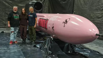 Jan Polak, right, and Martin Ondracek, left, from the Czech organization, Weapons to Ukraine, together with Iryna Terekh, Chief Technology Officer of the Fire Point factory, center, pose for photo by a Flamingo cruise missile, which was paid for by Czech crowdfunding campaign, at the Fire Point factory at an undisclosed location in Ukraine, Sunday, Nov. 16, 2025. (AP Photo/Efrem Lukatsky)