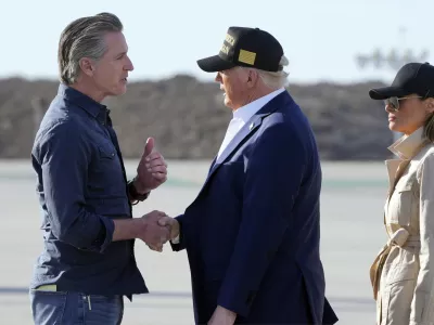 President Donald Trump talks with California Gov. Gavin Newsom as first lady Melania Trump listens after arriving on Air Force One at Los Angeles International Airport in Los Angeles, Friday, Jan. 24, 2025. (AP Photo/Mark Schiefelbein)