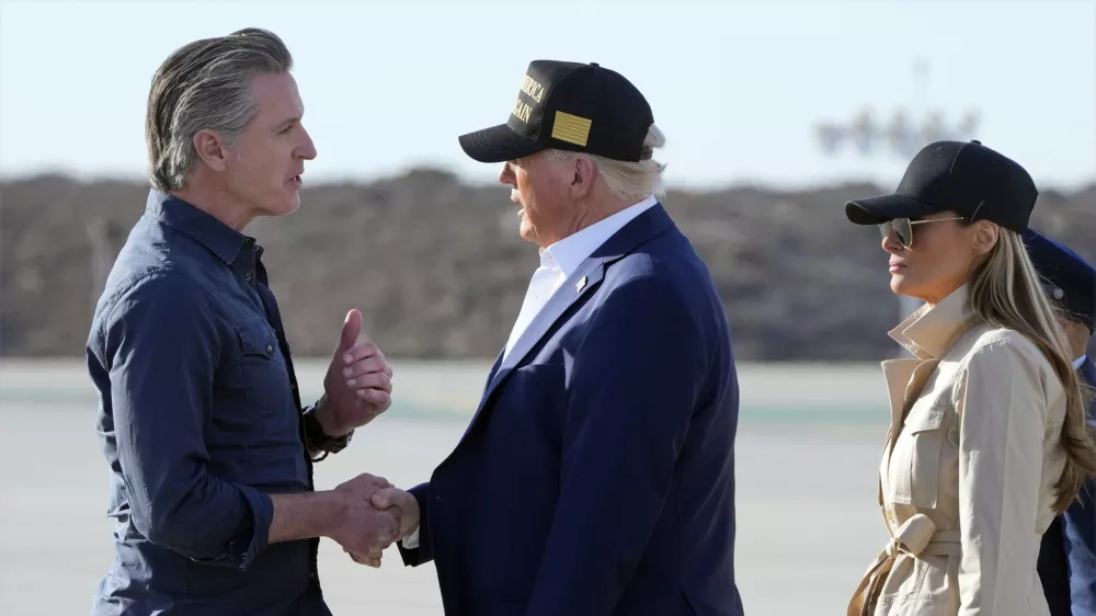 President Donald Trump talks with California Gov. Gavin Newsom as first lady Melania Trump listens after arriving on Air Force One at Los Angeles International Airport in Los Angeles, Friday, Jan. 24, 2025. (AP Photo/Mark Schiefelbein)