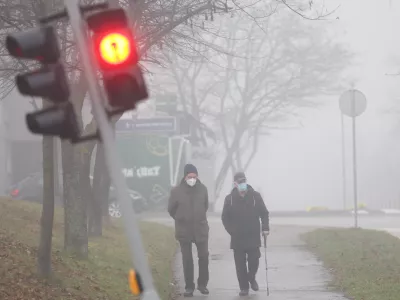Men wear face masks on a foggy day in Sarajevo, Bosnia, Thursday, Dec. 18, 2025. (AP Photo/Armin Durgut)