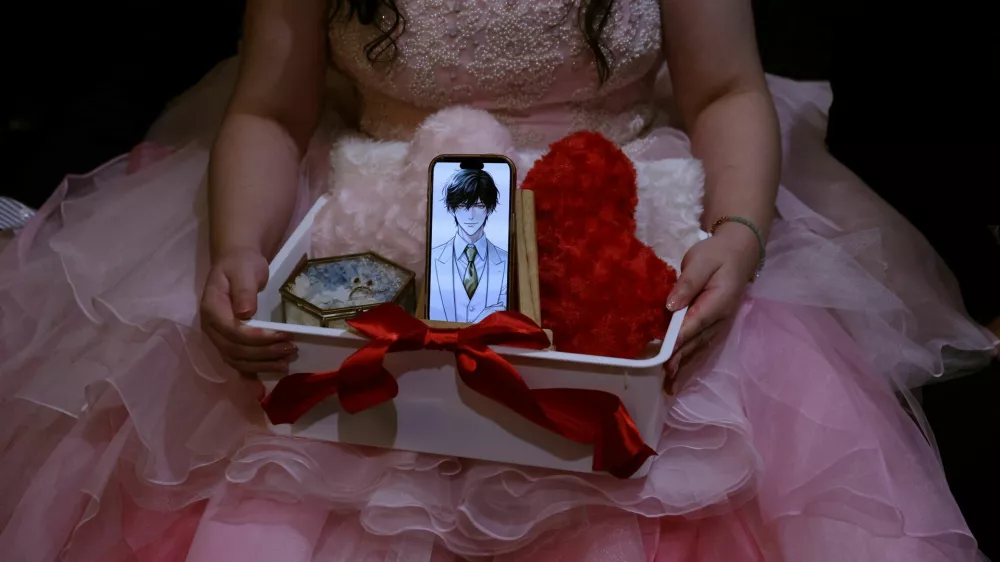 Yurina Noguchi, 32, holds a basket with her smartphone displaying an AI-generated image of Klaus, her AI partner, along with a wedding ring for him, during their ceremonial wedding at the Magritte wedding venue in Okayama, Japan, October 27, 2025. REUTERS/Kim Kyung-Hoon  SEARCH "JAPAN KYUNG-HOON AI WEDDING" FOR THIS STORY. SEARCH "WIDER IMAGE" FOR ALL STORIES.