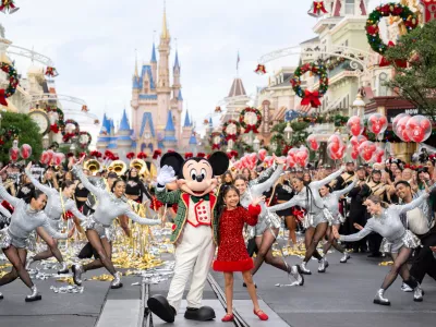 This image released by Disney shows Mickey Mouse and Maia Kealoha from the 40th Anniversary Disney Parks Magical Christmas Day Parade in Orlando, Fla. (Kenslie McGuire/Disney via AP) / Foto: Kenslie Mcguire
