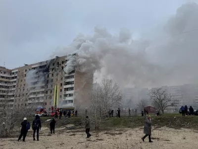 FILE PHOTO: Residents walk in front of an apartment building hit by a Russian air strike, amid Russia's attack on Ukraine, in Zaporizhzhia, Ukraine December 17, 2025. REUTERS/Stringer/File Photo