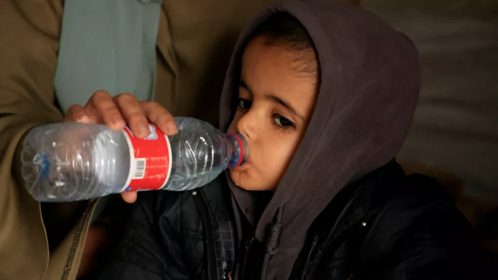Displaced Palestinian child Yasser Arafat, 5, who, according to medics, suffers from severe acute malnutrition with nutritional edema, drinks water inside their family's tent at a displacement camp in Khan Younis, southern Gaza Strip, December 16, 2025. REUTERS/Haseeb Alwazeer