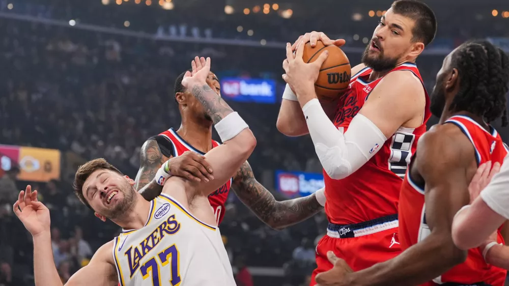 Los Angeles Clippers center Ivica Zubac, left, gets a rebound against Los Angeles Lakers forward/guard Luka Doncic during the first half of an NBA basketball game Saturday, Dec. 20, 2025, in Inglewood, Calif. (AP Photo/Jae C. Hong)