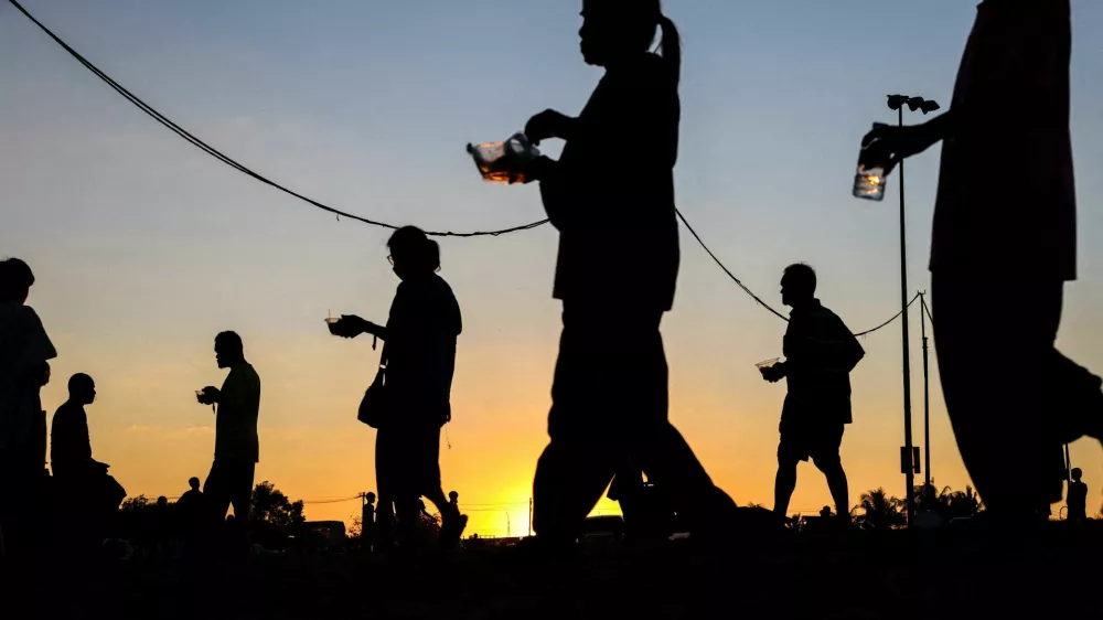 FILE PHOTO: Displaced people walk after receiving food at a temporary shelter amid clashes between Thailand and Cambodia along a disputed border area, in Buriram province, Thailand, December 16, 2025. REUTERS/Athit Perawongmetha/File Photo
