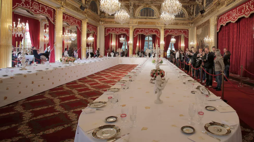 FILE - Visitors view a table dressed with plates and glasses for official dinners at the Elysee Palace in Paris, Saturday, Sept. 15, 2012. France's national buildings and administrations were opened to the public for Heritage Days weekend. (AP Photo/Christophe Ena, File)