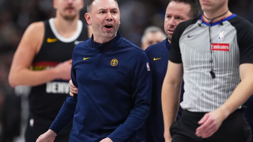 Denver Nuggets head coach David Adelman, front left, reacts after being ejected by referee Tyler Ricks, right, as assistant coach J.J. Barea, second from right, holds him back in the second half of an NBA basketball game against the Houston Rockets, Saturday, Dec. 20, 2025, in Denver. (AP Photo/David Zalubowski)