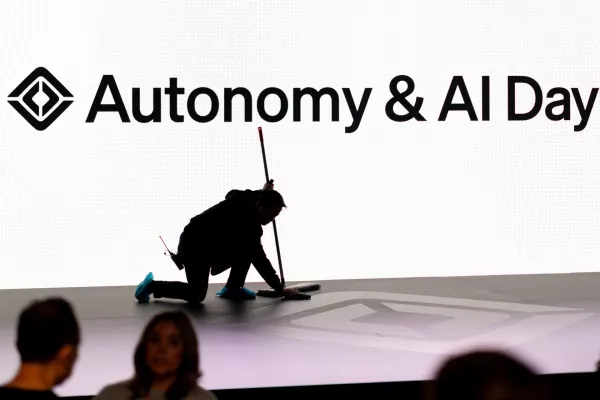 A man cleans a stage floor as attendees gather during Rivian's first Autonomy and AI (artificial intelligence) Day, showcasing developments in self-driving technology, in Palo Alto, California, U.S., December 11, 2025. REUTERS/Carlos Barria