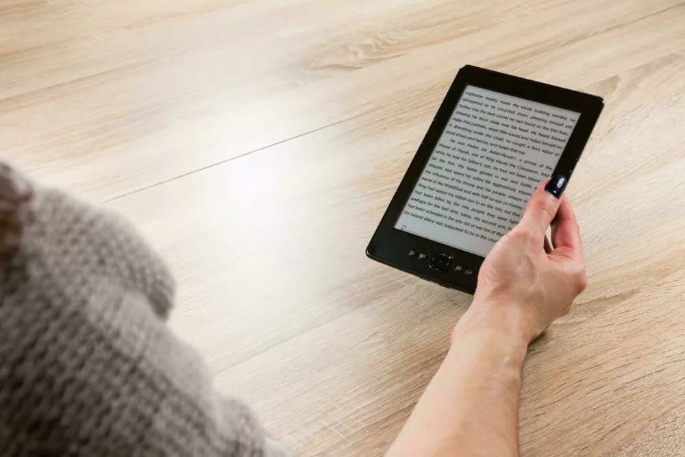HTC209 Woman holding ebook reader in front of the table