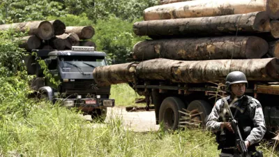 A soldier stands guard in front of a truck loaded with logs that were illegally cut from the Amazon rain forest in Tailandia,in the northern Brazilian state of Para, Monday, Feb. 25, 2008. About 200 heavily armed troops of Brazil's Top National Police Force arrived Monday in this remote town of the northern jungle state of Para to boost efforts to crack down on illegal logging, the government news service Agencia Brasil said. (AP Photo/Beto Barata-Agencia Estado)