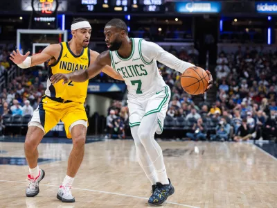 Dec 26, 2025; Indianapolis, Indiana, USA; Boston Celtics guard/forward Jaylen Brown (7) dribbles the ball while Indiana Pacers guard/forward Andrew Nembhard (2) defends in the second half at Gainbridge Fieldhouse. Mandatory Credit: Trevor Ruszkowski-Imagn Images