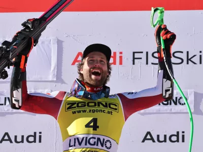 Austria's Marco Schwarz celebrates on the podium after winning an alpine ski, men's World Cup Super G, in Livigno, Italy, Saturday, Dec. 27, 2025. (AP Photo/Marco Trovati)
