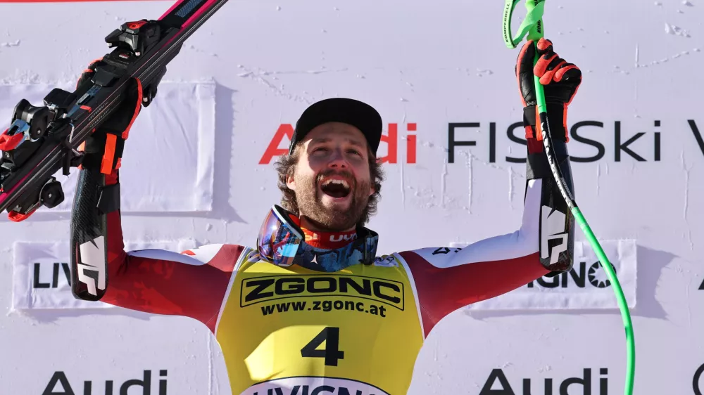 Austria's Marco Schwarz celebrates on the podium after winning an alpine ski, men's World Cup Super G, in Livigno, Italy, Saturday, Dec. 27, 2025. (AP Photo/Marco Trovati)