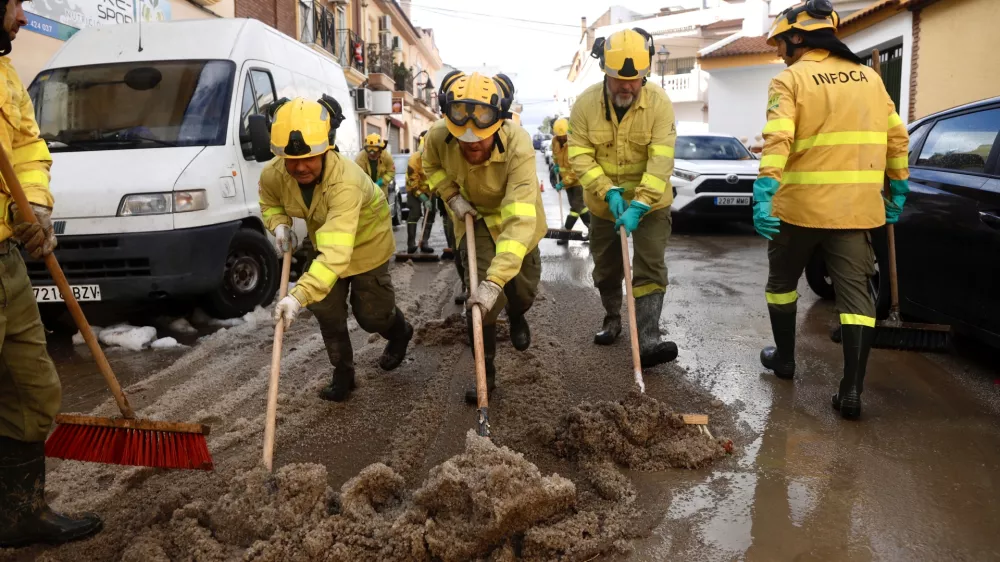 28 December 2025, Spain, Cartama: Infoca personnel clean the flooded streets in the neighborhood of Los Cardiales in Cartama following heavy rains in Malaga. The government has activated the Infoca Plan to carry out conditioning work in the Malaga municipality of Cartama, one of the most affected localities after heavy rains. Photo: &Aacute;lex Zea/EUROPA PRESS/dpa