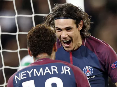 PSG's Edinson Cavani, right, celebrates after scoring his side's third goal with his teammate Neymar during a Champions League Group B soccer match between Paris St. Germain and Celtic at the Parc des Princes stadium in Paris, France, Wednesday, Nov. 22, 2017. Banner in the middle reads: Never alone. (AP Photo/Christophe Ena)