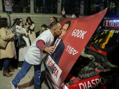 A man kisses a hood of a car with an image of Kosovo's Prime Minister and Levizja Vetevendosje (Movement for Self-Determination) party leader Albin Kurti, as the party leads in early vote results, on the day of a snap parliamentary election, nearly a year after a political deadlock that prevented the formation of a new government, in Pristina, Kosovo, December 28, 2025. REUTERS/Valdrin Xhemaj REFILE - CORRECTING INFORMATION FROM "KISSES A POSTER" TO "KISSES A HOOD OF A CAR".