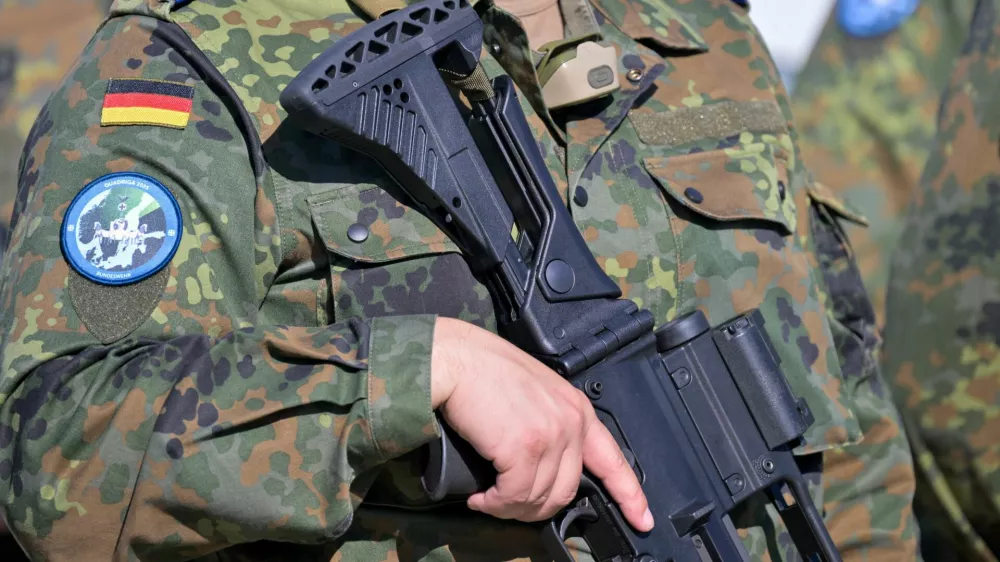 A soldier holds a weapon as he arrives during a media day at a Convoy Support Center (CSC), a logistical hub providing rest, supplies, accommodation, security services and assembly areas to support military troop movements in Germany, as Bundeswehr prepares to advance to Lithuania in the next days to attend the "Quadriga 2025" excercise, in Weisskeissel, Germany, September 6, 2025. REUTERS/Matthias Rietschell