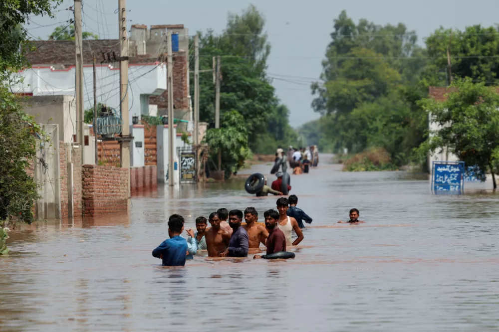 Residents wade through a flooded road, following monsoon rains and rising water levels in Qadirabad village near the Chenab River in Punjab province, Pakistan August 28, 2025. REUTERS/Akhtar Soomro / Foto: Akhtar Soomro