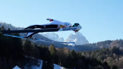 Domen Prevc, of Slovenia, soars through the air, with the Zugspitze and Waxenstein mountains in the background, during his trial jump at the second stage of the Four Hills ski jumping tournament in Garmisch-Partenkirchen, Germany, Wednesday, Dec. 31, 2025. (AP Photo/Matthias Schrader)