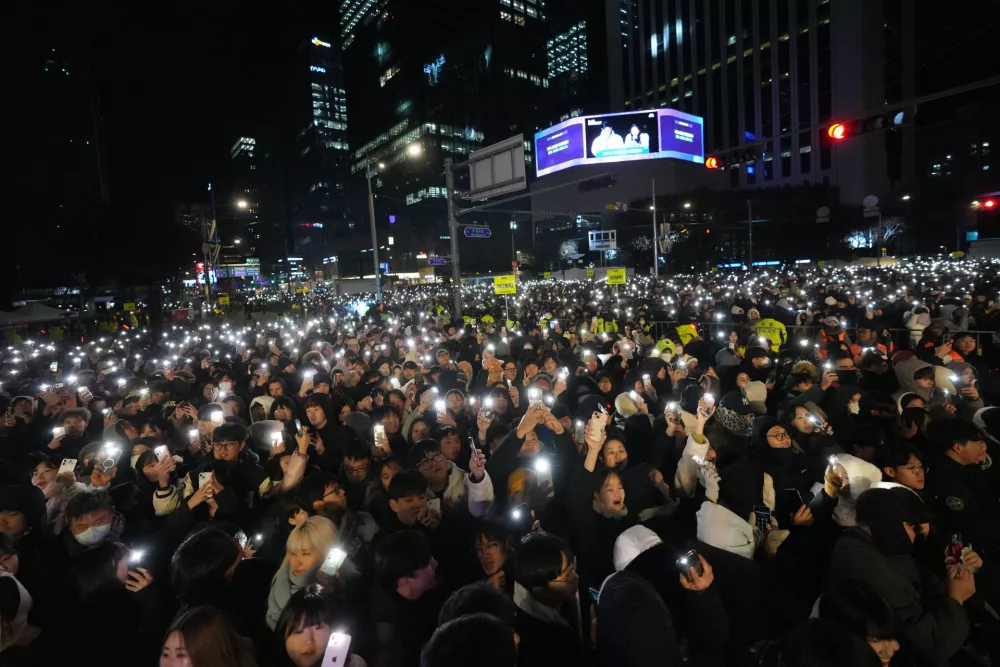 People gather before the New Year's countdown event in front of the Bosingak pavilion where the annual New Year's bell-ringing ceremony is held in Seoul, South Korea, Wednesday, Dec. 31, 2025. (AP Photo/Lee Jin-man)