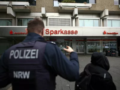 Police talks to people after thieves used the quiet Christmas period to drill their way into the vault of a branch of Sparkasse bank and make off with money and valuables from customers' safe deposit boxes in Gelsenkirchen, Germany, December 31, 2025.  REUTERS/Thilo Schmuelgen