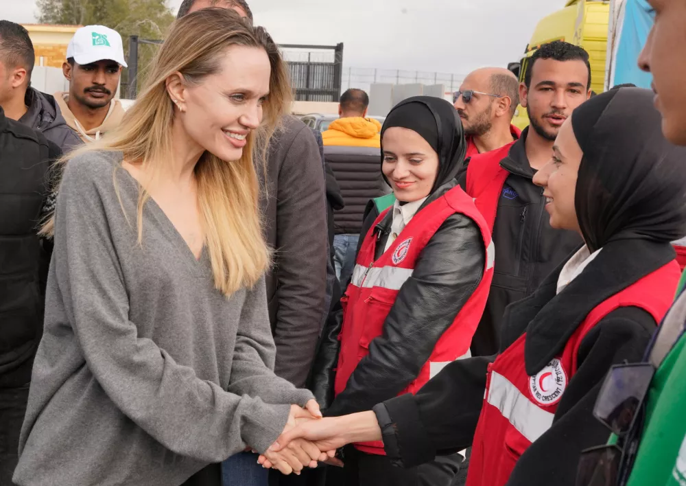 American actor and film producer Angelina Jolie, front left, greets Red Crecent workers during her visit to the Rafah border crossing between Egypt and the Gaza Strip in Rafah, Egypt, Friday, Jan. 2, 2026. (AP Photo/Mohamed Arafat)