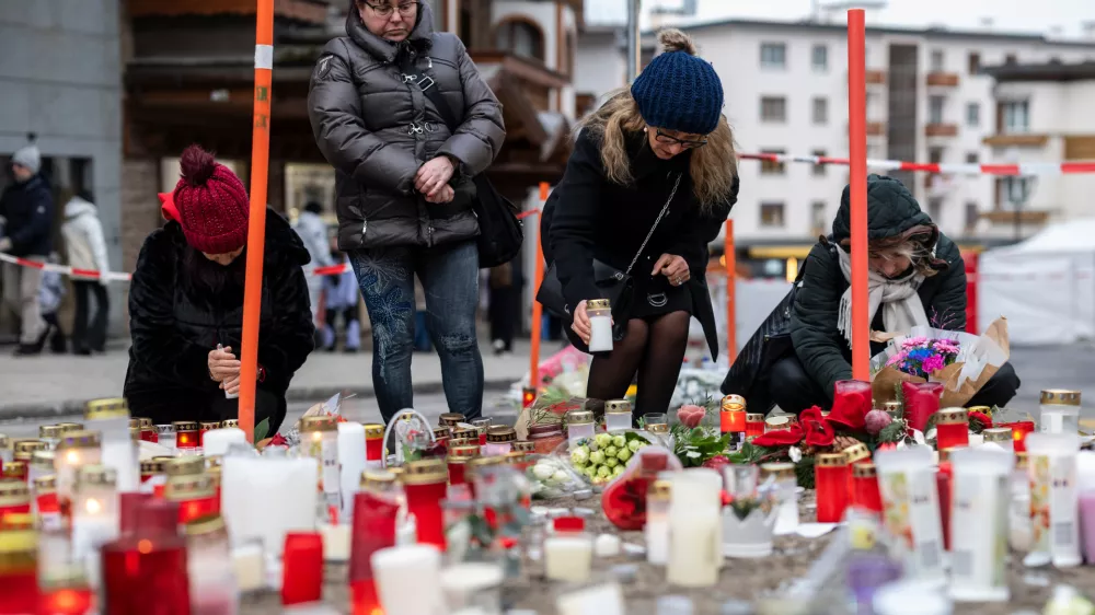 People light candles near the sealed off Le Constellation bar, where a devastating fire left dead and injured during the New Year's celebrations in Crans-Montana, Swiss Alps, Switzerland, Friday, Jan. 2, 2026. (Alessandro della Valle/Keystone via AP)