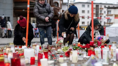 People light candles near the sealed off Le Constellation bar, where a devastating fire left dead and injured during the New Year's celebrations in Crans-Montana, Swiss Alps, Switzerland, Friday, Jan. 2, 2026. (Alessandro della Valle/Keystone via AP)