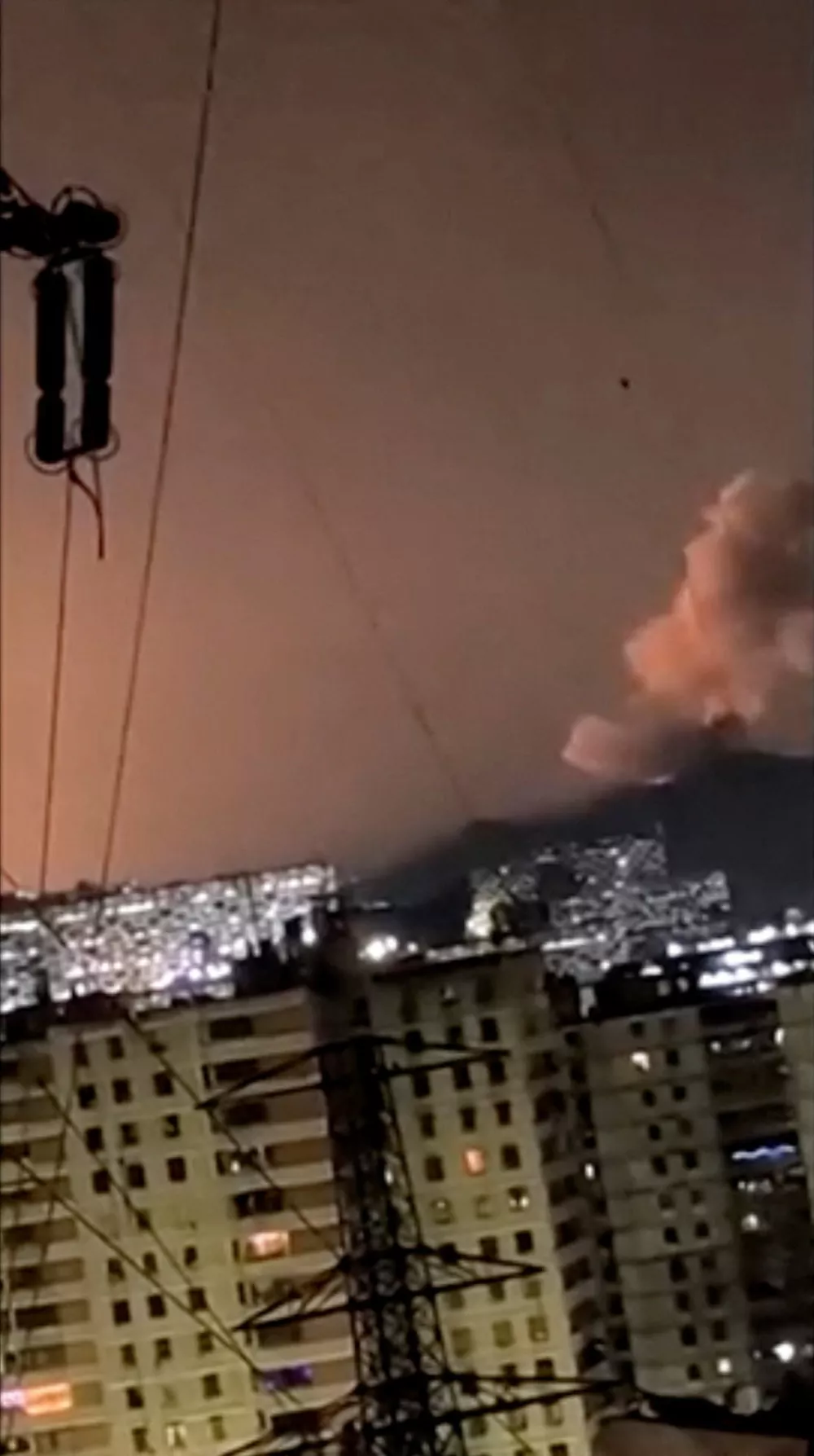 A column of smoke rises following an explosion, as the sky is illuminated by another explosion in the distance in the early hours of the morning, in Caracas, Venezuela, January 3, 2026 in this screen grab obtained from video obtained by Reuters. Video Obtained by Reuters/via REUTERS THIS IMAGE HAS BEEN SUPPLIED BY A THIRD PARTY.