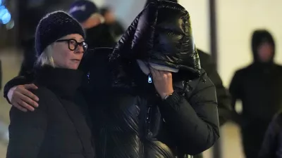 People mourn near the sealed off Le Constellation bar in Crans-Montana, Swiss Alps, Switzerland, Friday, Jan. 2, 2026, where a devastating fire left dead and injured during the New Year's celebrations. (AP Photo/ Antonio Calanni)